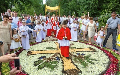 Procesja z Najświętszym Sakramentem po kwiatowych dywanach w Spycimierzu.