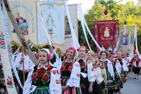 Kapłana niosącego Najświętszy Sakrament poprzedzały liczne chorągwie niesione przez wiernych w strojach ludowych