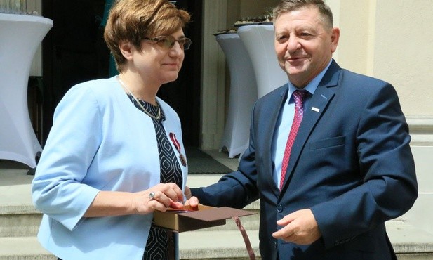 Anna Fic-Lazor odbiera medal z rąk Waldemara Podsiadłego, pełnomocnika wojewody lubelskiego do spraw ochrony dziedzictwa narodowego i spraw kombatantów