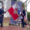 Poświęcony sztandar przekazuje uczniom Jan Słuszniak, dyrektor placówki.