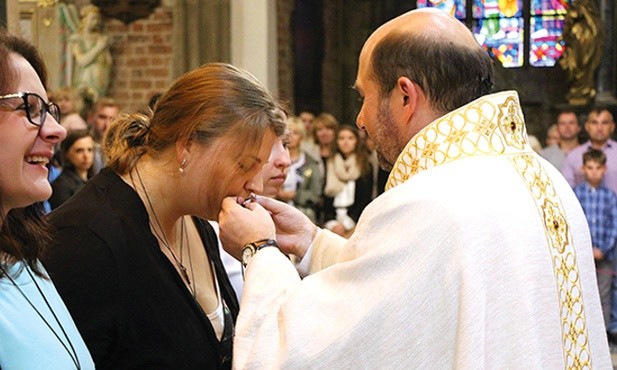Magdalena całuje pobłogosławiony wcześniej krzyż misyjny.