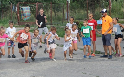 Mariusz Mędra daje sygnał "start" młodym zawodnikom biegu ulicznego