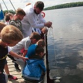 Radosław Wąs bada przejrzystość wód krążkiem Secchiego.