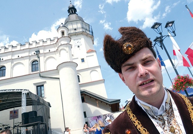 Do odwiedzin zaprasza Tomasz Jakubowski. Na drugim planie szydłowiecki ratusz.