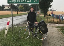 Ksiądz Jakub Kępczyński w Łasku, przy tablicy wskazującej pozostałe kilometry  do Częstochowy.
