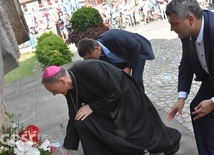 Biskup Adam i władze miasta Ząbkowic Śląskich składający kwiaty i znicze pod pomnikiem.