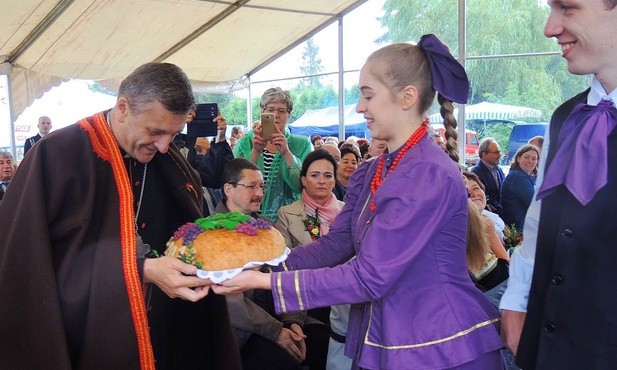 Bp Roman Pindel przyjmuje chleb z tegorocznych plonów z rąk młodych z zespołu "Ziemia Beskidzka"