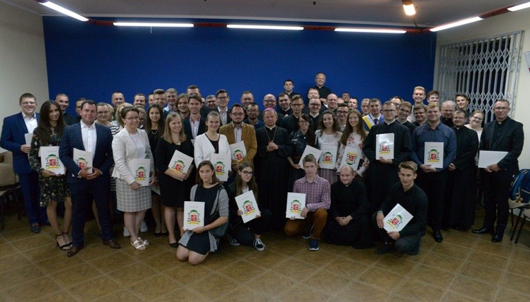 Pamiątkowa fotografia członków powołanych centrów i rady z bp. Henrykiem Tomasikiem. Z prawej ks. Mariusz Wilk