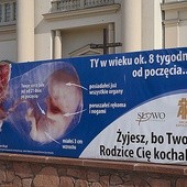 Billboard na ogrodzeniu kościoła NSJ.