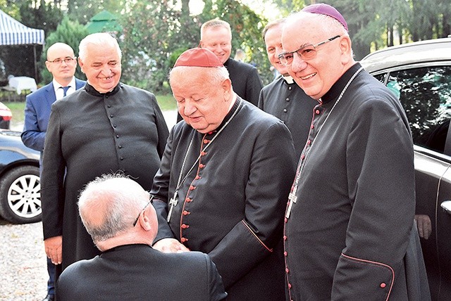 Ks. Tadeusz Pawlas klęka przed kard. Dziwiszem, witając go u Matki Bożej.