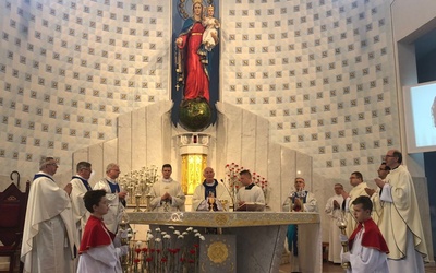 Kapłani przy ołtarzu ofiarnym w czasie uroczystej Mszy św.