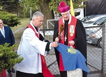 Biskup Ignacy przy kamiennym oznaczeniu i tablicy informacyjnej.