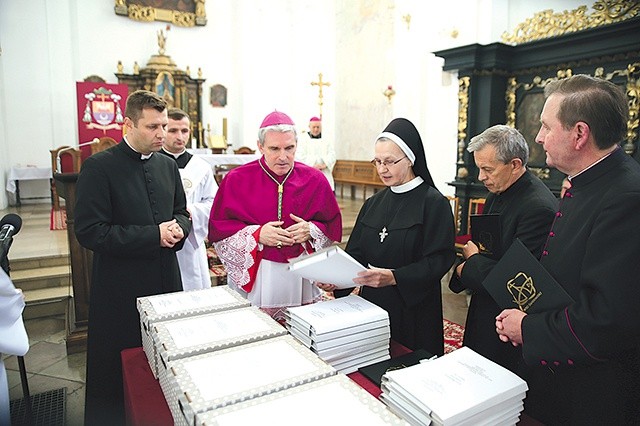 ▲	Notariusze trybunału przedstawili biskupowi akta procesowe.