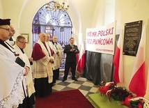 Biskupi i kapłani pod tablicą pamięci poległych.