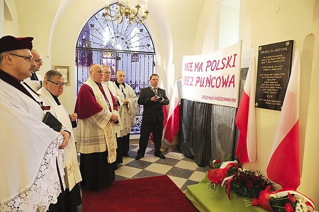 Biskupi i kapłani pod tablicą pamięci poległych.