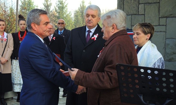 Burmistrz Wilamowic Marian Trela i przewodniczący Rady Miasta Stanisław Nycz wręczają Dariuszowi Pilarskiemu akt nadania jego dziadkowi tytułu Honorowego Obywatela Gminy