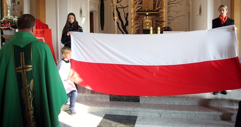 Cześć biało-czerwonej fladze oddaje ks. Tomasz Gaik