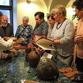 Seniorzy przy stoisku zajęć z historii średniowiecza