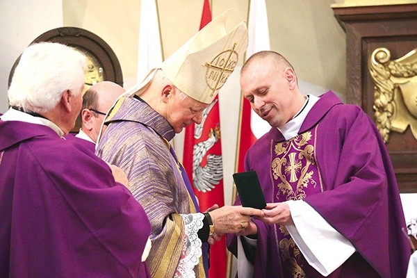 Biskupowi Adamowi Odzimkowi okolicznościową odznakę wręczył ks. Kryspin Rak.