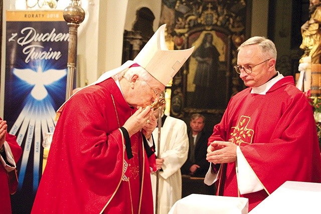 Ordynariusz łowicki całuje relikwiarz z cząstką kości błogosławionego.