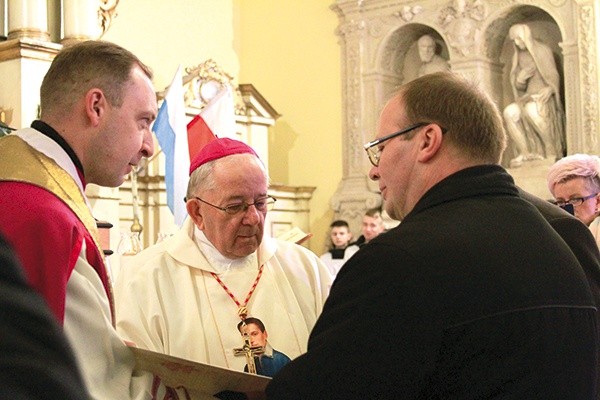 ▲	Biskup senior wręczył włodarzom miasta dokument z Watykanu.