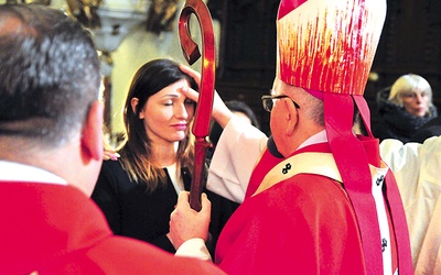 Metropolita lubelski podczas udzielania sakramentu bierzmowania dorosłym.