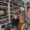 Pani Bożena i pan Ryszard z wnukiem Szymonem oglądają zdjęcia rodzinne wykonane przez córkę Martę.