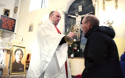 O. Rafał Sebastian Pujsza CP podaje relikwiarz do ucałowania.