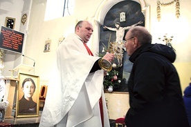 O. Rafał Sebastian Pujsza CP podaje relikwiarz do ucałowania.