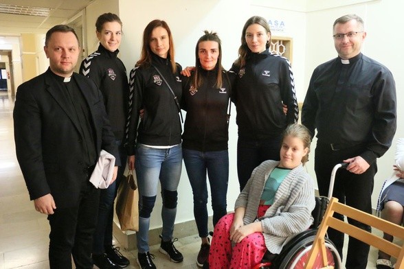 Piłkarki ręczne ze swym kapelanem ks. G. Bzdyrakiem oraz dyrektorem Caritas odwiedziły chore dzieci
