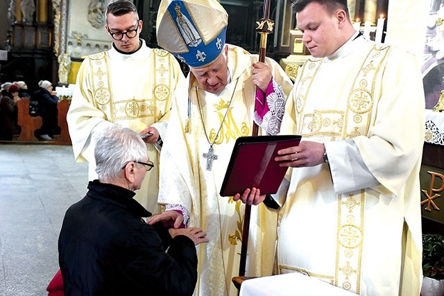 Biskup Ignacy udzielający sakramentu chorych wiernym w świdnickiej katedrze.