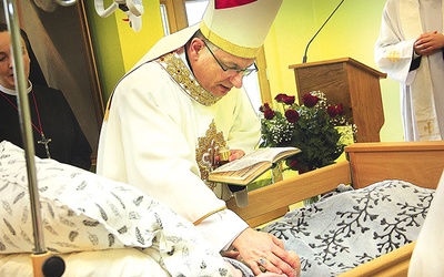 Koszalińsko-kołobrzeski biskup pomocniczy udziela pacjentom terminalnym sakramentu namaszczenia.