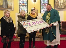 Dzieci z parafii w Żórawinie przekazują symboliczny, przygotowany przez siebie czek ks. Waldemarowi Cisło.