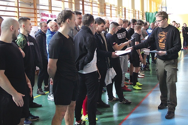 ▲	Adam Szabelak rozdaje zawodnikom tekst modlitwy Narodowych Sił Zbrojnych, którą za chwilę wspólnie odmówią.