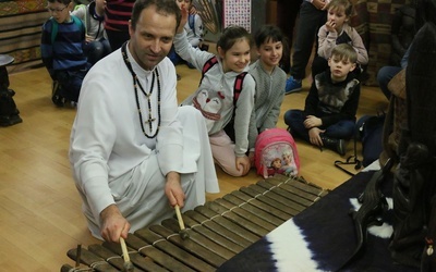 Ojciec Mariusz pokazuje afrykańskie cymbałki.