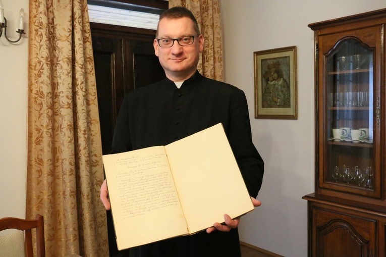 Ks. Wojciech pokazuje wpis błogosławionego w kronice parafialnej.