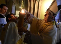 Biskup odpalający świecę od paschału.