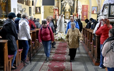 Pielgrzymi w drodze niosą figurę Matki Bożej.