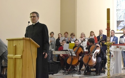 Ks. Mirosław Rakoczy przed konferencją, a w tle diakonia muzyczna.