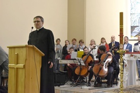 Ks. Mirosław Rakoczy przed konferencją, a w tle diakonia muzyczna.