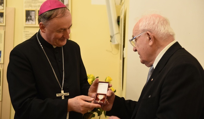 Karol Krasnodębski przekazuje Krzyż Wolności i Solidarności bp. Andrzejowi Jeżowi jako wotum wdzięczności za świętych kapłanów, którzy byli przy internowanych i ich rodzinach w trudnych latach stanu wojennego.