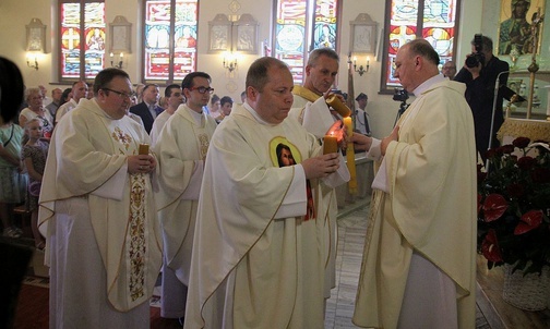 Pochodzący ze Słotwiny duszpasterze przynieśl do ołtarza świece.