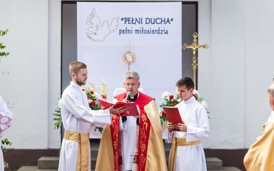 Modlitwa przy domu zbudowanym dla wystawienia Najświętszego Sakramentu podczas procesji Bozego Ciała.