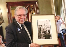 Jubilat z odbitką fotografii sprzed 60 lat, przedstawiającą go (po lewej) na planie kręconego w Nowej Hucie debiutanckiego filmu fabularnego „Cement i słowa”.  Obok niego Wojciech Plewiński i Maria Przybylska.