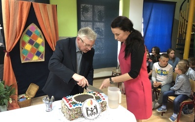Urodzinowy tort zdobiło logo "Ignis", a kroili: ks. Ignacy Czader i Agnieszka Habrzyk, obecna szefowa świetlicy