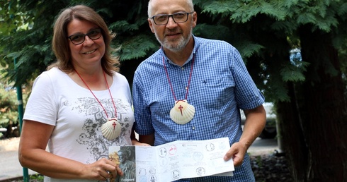 Beata i Marek Sokołowscy z muszlami św. Jakuba, symbolem Camino, oraz pieczętowanym na trasie paszportem pielgrzyma.