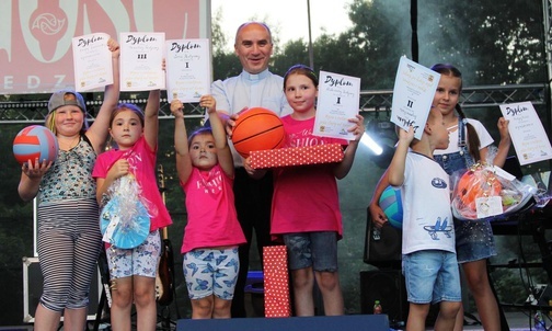 Mali zwycięzcy konkursu plastycznego z ks. proboszczem Wiesławem Ostrowskim.