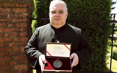 Ksiądz Piotr Lisowski z medalem Polonia Minor, przyznanym parafii przez Województwo Małopolskie i sejmik.