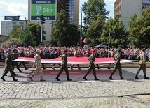 Przemarsz wojsk rozpoczęli żołnierze niosący flagę Polski.