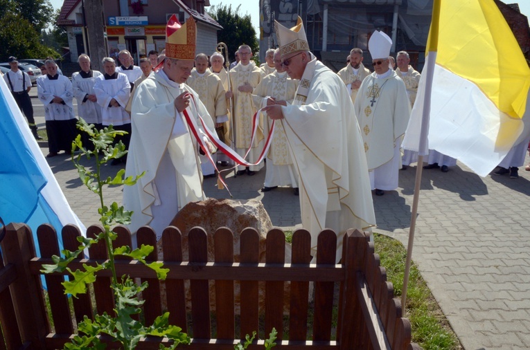 Kamień ustawiony przy dębie "Ludwik", który będzie żywą pamiątką obchodów, odsłonili biskupi Henryk Tomasik (z lewej) i Artur Miziński.